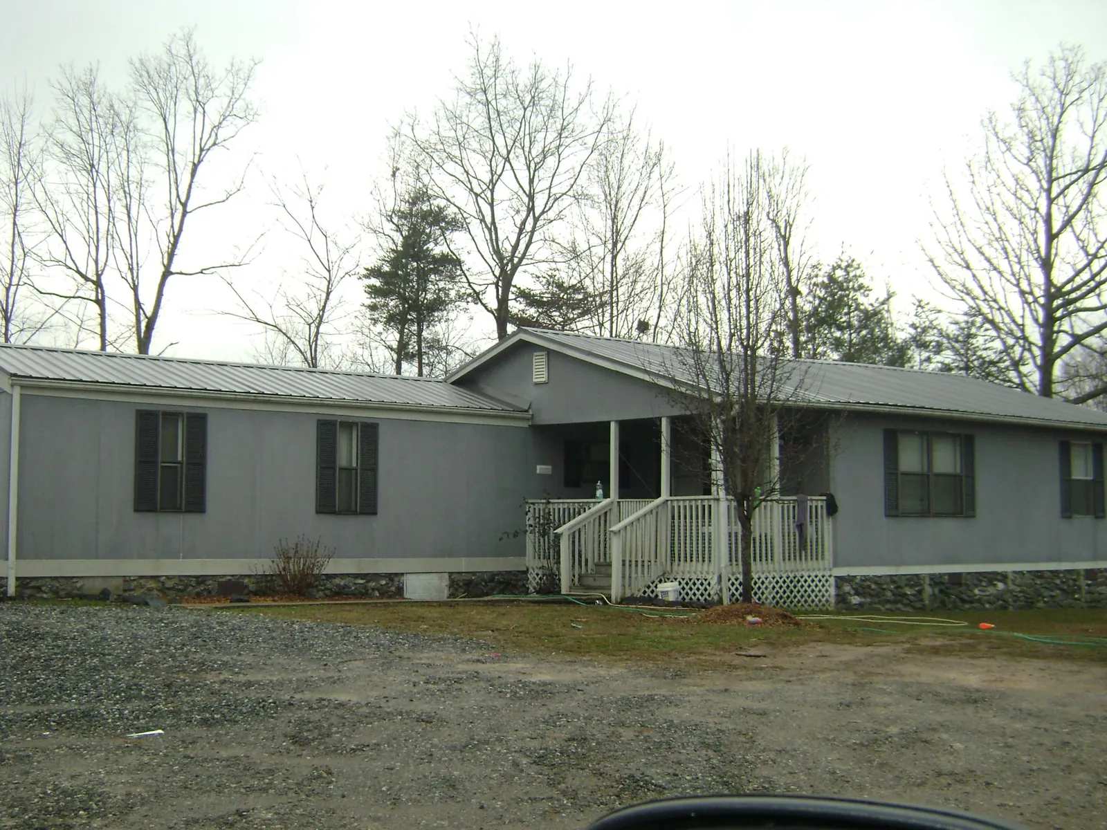 Metal roof over a manufactured home with a covered front porch in Paulina
