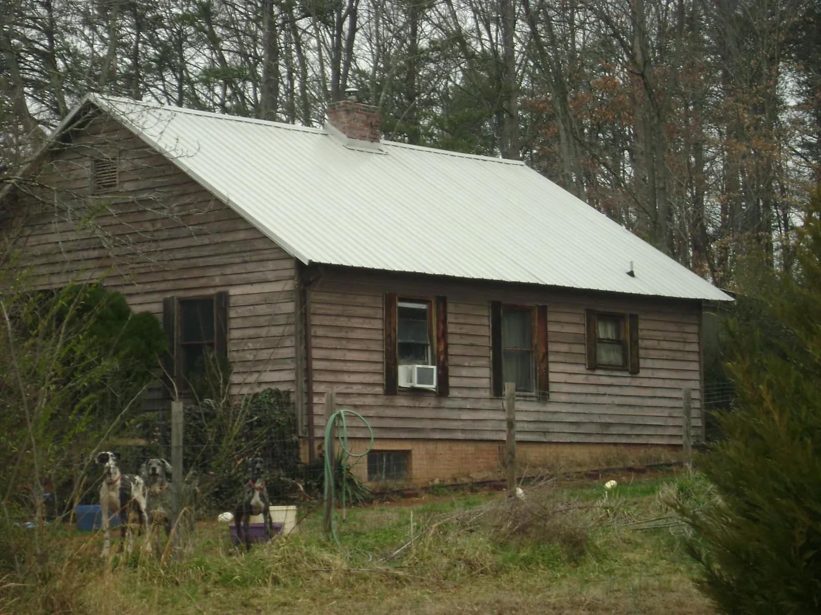 White metal roof on an old wood sided farmhouse, from a Metal Roof Installation job in Paulina